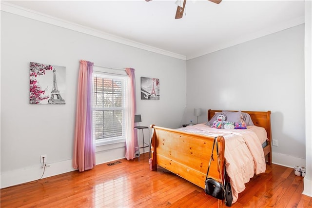 bedroom with ceiling fan, crown molding, and hardwood / wood-style floors