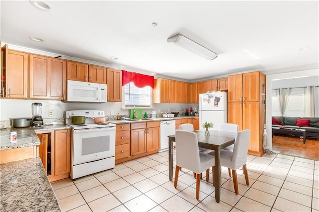 kitchen featuring light stone countertops, light tile patterned flooring, sink, and white appliances