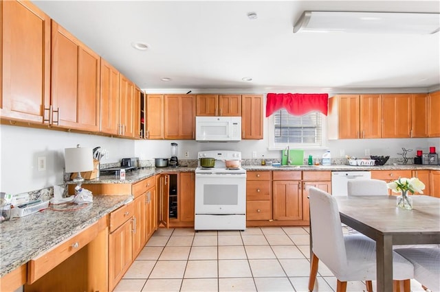 kitchen with light stone counters, sink, white appliances, and light tile patterned flooring