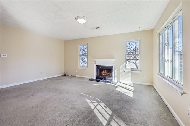 1056 Shadow Lake Dr, Lithonia, GA 30058 - unfurnished living room with healthy amount of natural light, carpet floors, a fireplace with flush hearth, and a textured ceiling