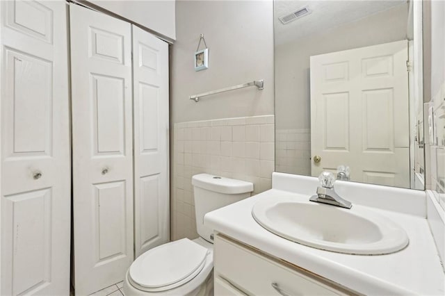 1056 Shadow Lake Dr, Lithonia, GA 30058 - bathroom with a closet, vanity, tile walls, and a wainscoted wall