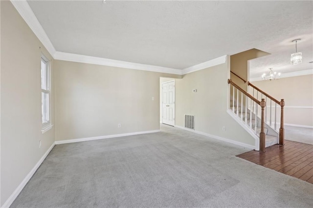 1056 Shadow Lake Dr, Lithonia, GA 30058 - unfurnished room with a chandelier, carpet floors, stairs, ornamental molding, and a textured ceiling