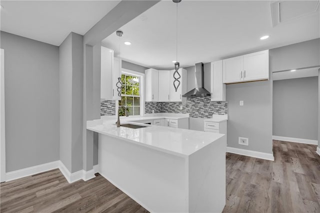 85 Ollie St, Atlanta, GA 30314 - kitchen with wall chimney exhaust hood, a peninsula, backsplash, wood finished floors, and recessed lighting