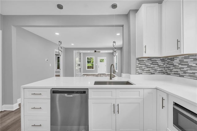 85 Ollie St, Atlanta, GA 30314 - kitchen with stainless steel dishwasher, a peninsula, light countertops, white cabinets, and recessed lighting
