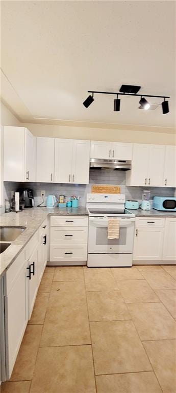 kitchen with white appliances, track lighting, light tile floors, sink, and white cabinetry