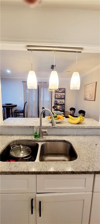 kitchen with sink, white cabinets, and light stone counters