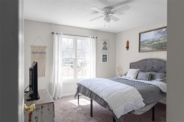 carpeted bedroom with ceiling fan, a textured ceiling, and baseboards