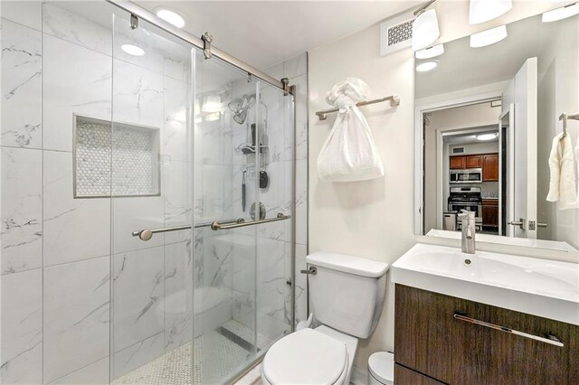 bathroom with vanity, an enclosed shower, and toilet