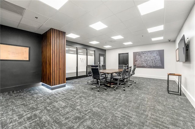 carpeted dining area with a paneled ceiling