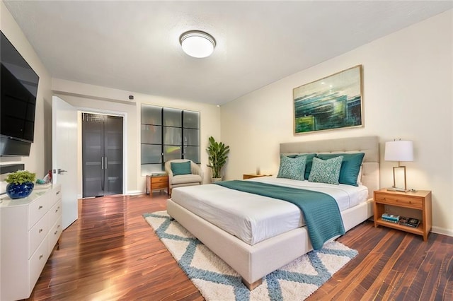 bedroom with dark hardwood / wood-style flooring and a closet