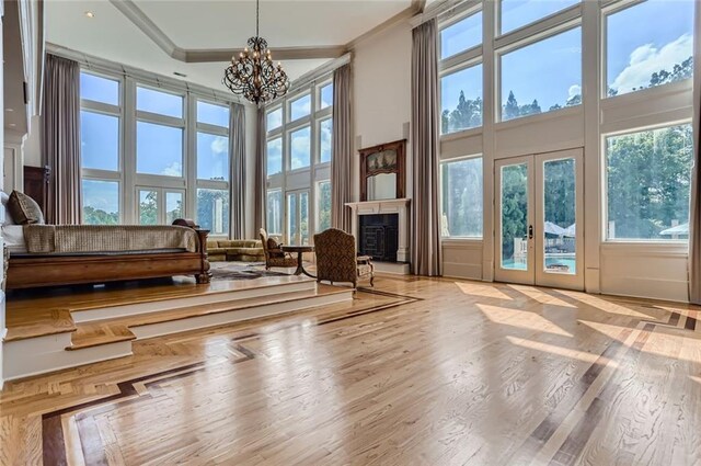 9620 Cedar Grove Rd, Chattahoochee Hills, GA 30213 - sitting room featuring a high ceiling, a chandelier, plenty of natural light, a fireplace, and ornamental molding