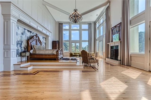 9620 Cedar Grove Rd, Chattahoochee Hills, GA 30213 - living area with a chandelier, wood finished floors, a fireplace, and a high ceiling