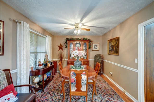 dining room featuring hardwood / wood-style floors, ceiling fan, and a textured ceiling