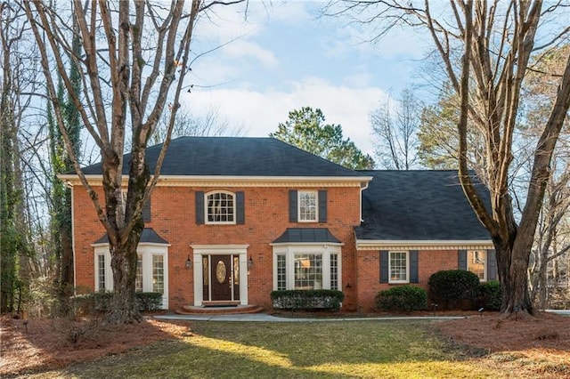 colonial house with brick siding and a front yard