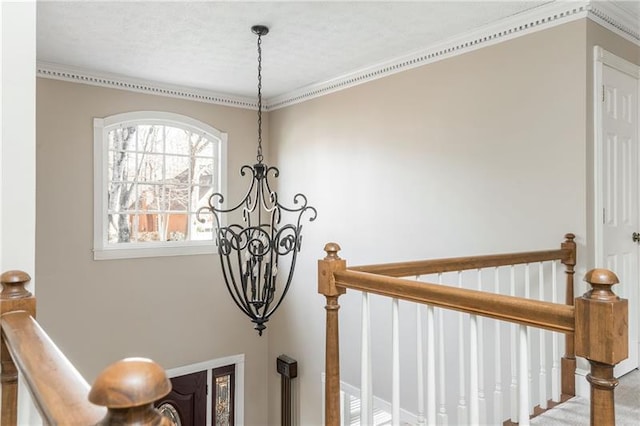 staircase with a chandelier and ornamental molding