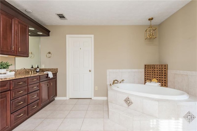 bathroom with visible vents, tile patterned flooring, double vanity, baseboards, and a bath