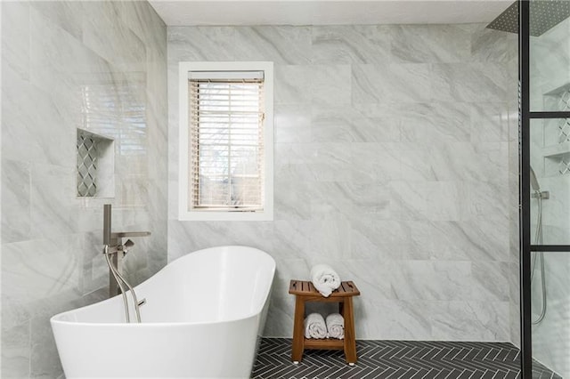 full bathroom featuring tiled shower, a freestanding bath, and tile walls