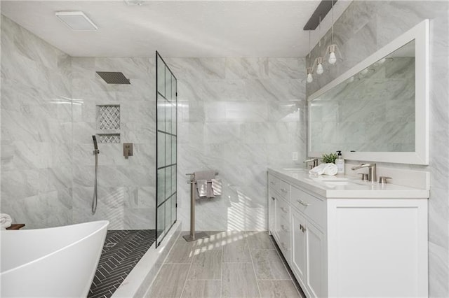 full bathroom featuring tile walls, double vanity, and tiled shower