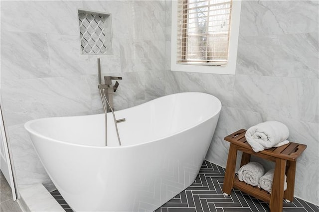 full bath with tile walls and a freestanding tub