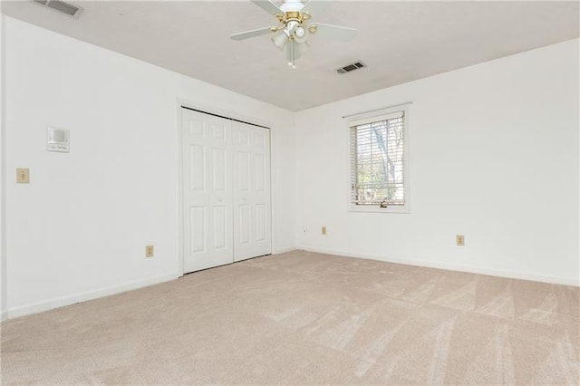 unfurnished bedroom with visible vents, baseboards, light colored carpet, and a closet