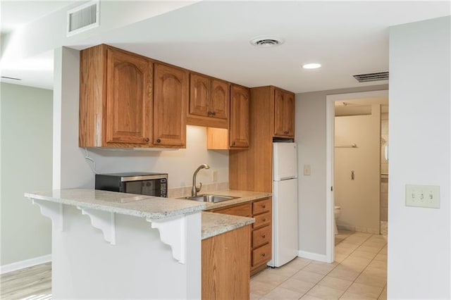 kitchen with a sink, visible vents, and a breakfast bar