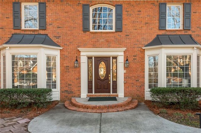 property entrance featuring a standing seam roof, brick siding, and metal roof