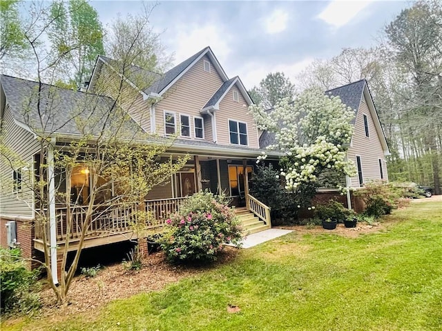 view of front of home with a front yard, covered porch, and brick siding