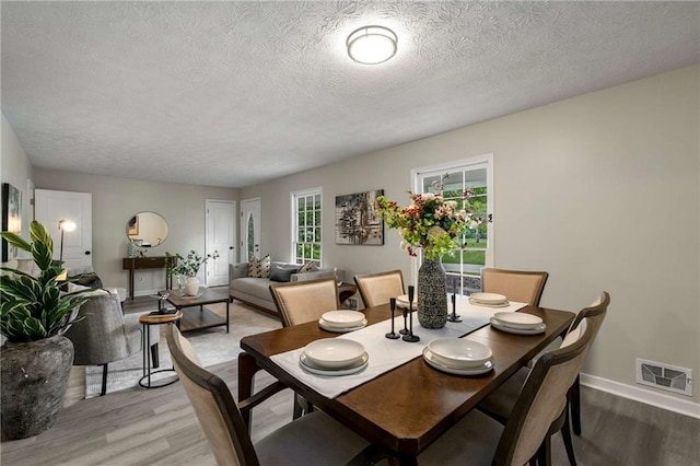 2694 Hickory Valley Dr, Snellville, GA 30078 - dining room with light wood-style flooring and a textured ceiling