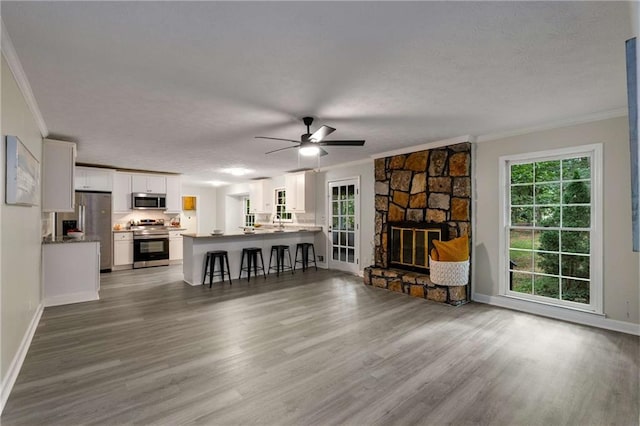 2694 Hickory Valley Dr, Snellville, GA 30078 - living area with ornamental molding, wood finished floors, a textured ceiling, a ceiling fan, and a fireplace