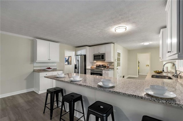 2694 Hickory Valley Dr, Snellville, GA 30078 - kitchen with appliances with stainless steel finishes, a peninsula, light stone countertops, white cabinets, and a textured ceiling