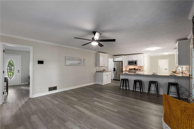 2694 Hickory Valley Dr, Snellville, GA 30078 - unfurnished living room featuring dark wood finished floors, ceiling fan, crown molding, and a textured ceiling