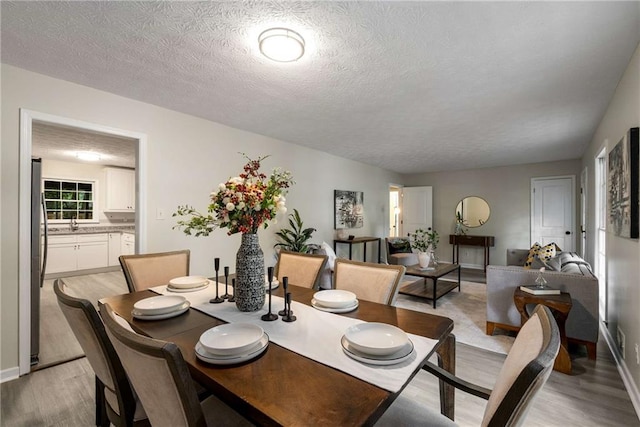2694 Hickory Valley Dr, Snellville, GA 30078 - dining room featuring light wood-style floors and a textured ceiling