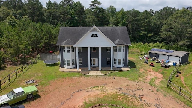 1120 Carl Bethlehem Rd, Winder, GA 30680 - view of front of house with a trampoline, an outdoor structure, a detached garage, a wooded view, and dirt driveway