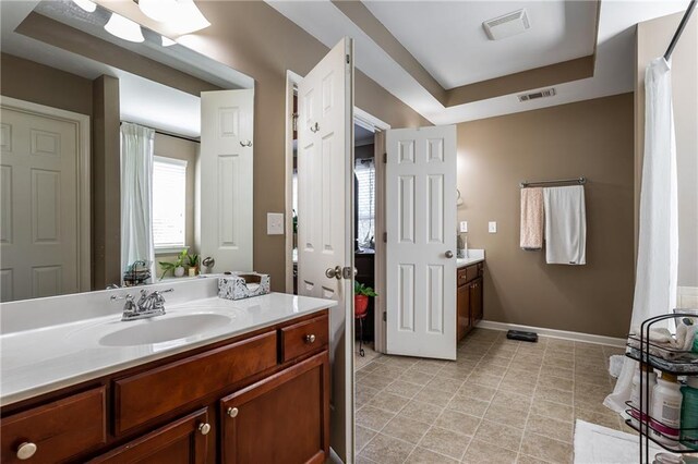 carpeted bedroom featuring a tray ceiling, ornamental molding, and ceiling fan