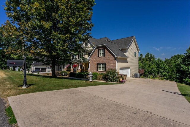 view of front of house featuring central AC, a garage, and a front lawn