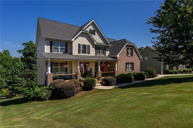 craftsman-style home with a front yard and covered porch