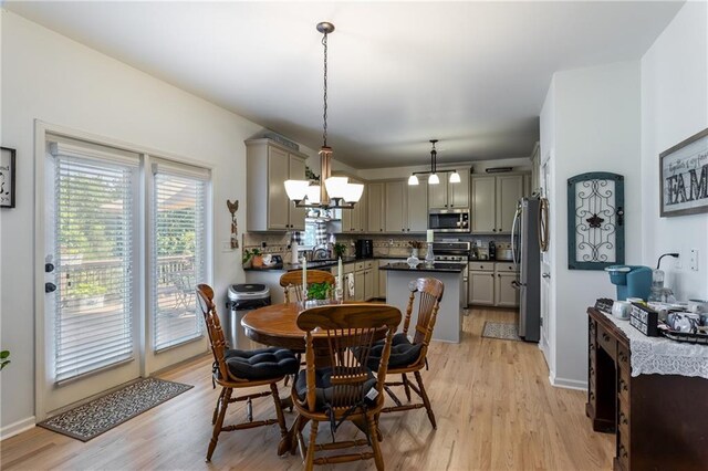 dining space featuring an inviting chandelier and light wood-type flooring