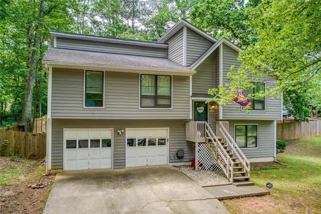 view of front of house featuring a garage, fence, and concrete driveway