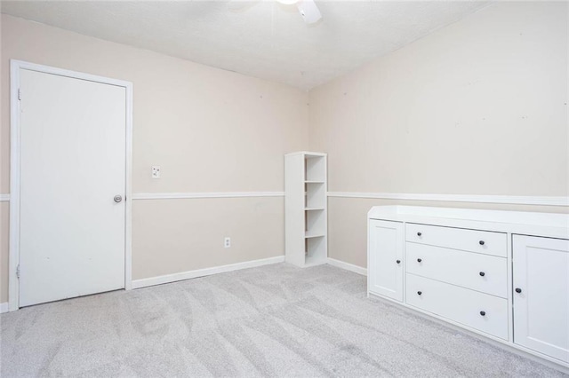 unfurnished bedroom with carpet, baseboards, and a ceiling fan