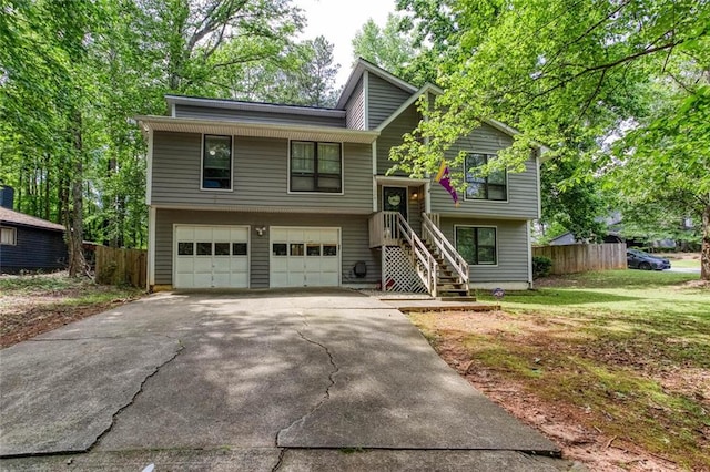 split foyer home featuring driveway, a garage, and stairway