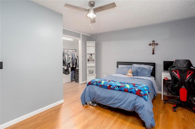 bedroom featuring wood finished floors, baseboards, and a closet