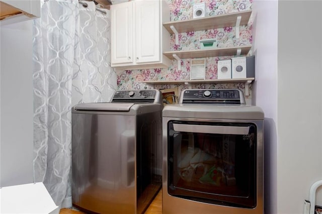 washroom featuring separate washer and dryer and cabinet space