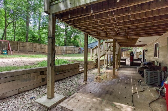 view of patio featuring a fenced backyard, central AC unit, and stairway