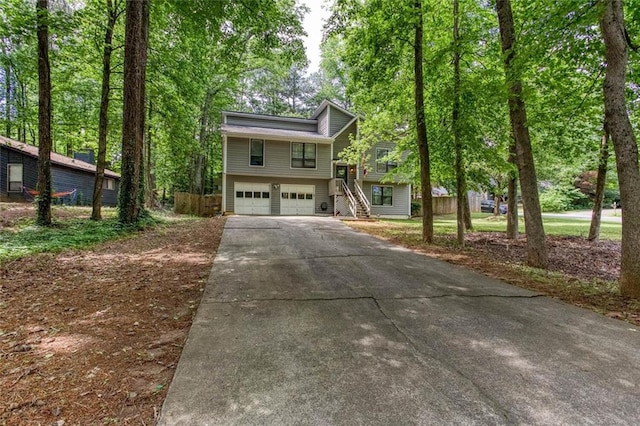 view of front of house featuring driveway, a garage, and stairs