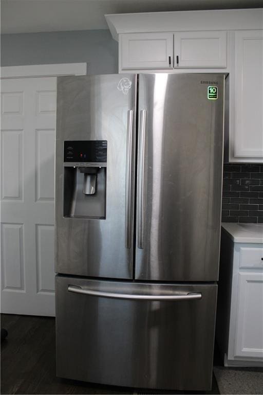 kitchen featuring white cabinets, stainless steel fridge with ice dispenser, and tasteful backsplash