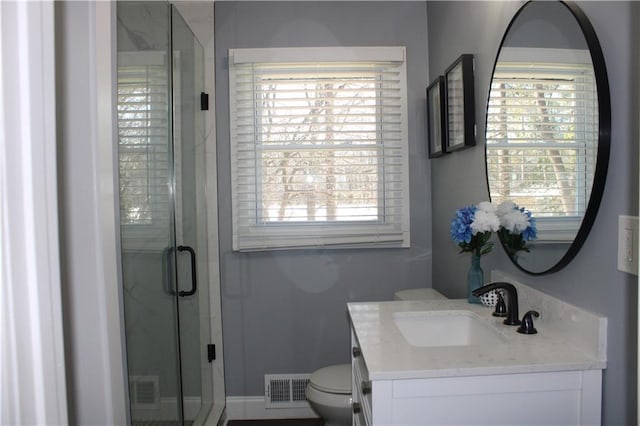 bathroom featuring vanity, toilet, and a shower with door