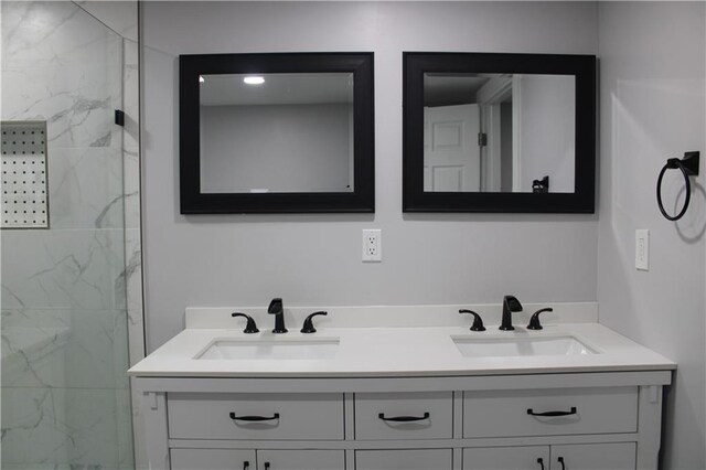 bathroom featuring tiled shower and vanity