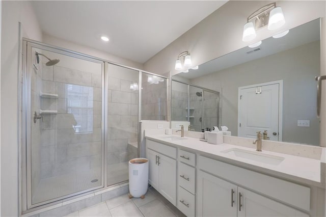 full bath with a stall shower, tile patterned flooring, and a sink