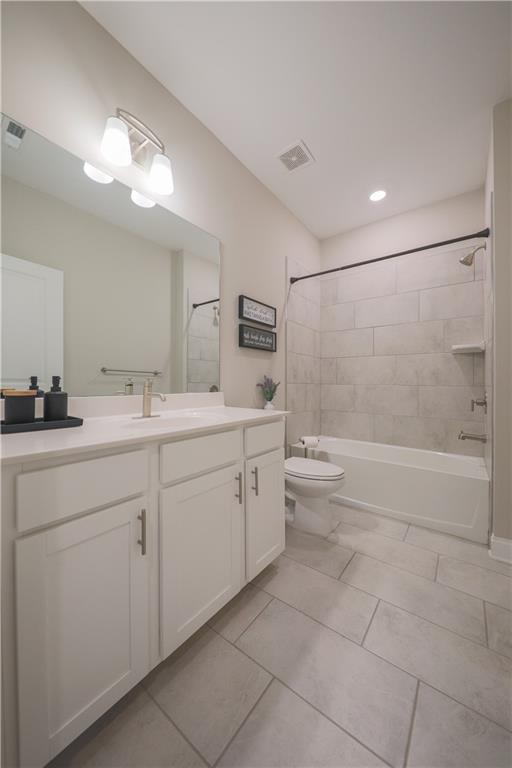 full bathroom featuring visible vents, vanity, bathtub / shower combination, and toilet