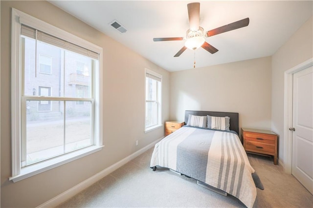 bedroom featuring visible vents, ceiling fan, light carpet, and baseboards